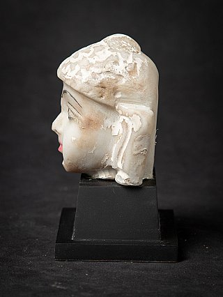 Marble Jain statue head in side profile, nose and ear visible