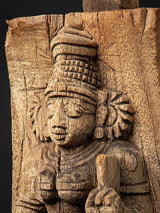 Angled face detail of Devi, showing the carved headdress and floral ear ornament