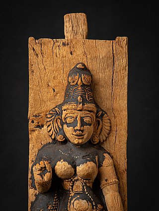 Close-up van de bovenhelft van Parvati in reliëf op hout, met zichtbare houtnerf erachter