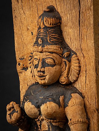 Schuin detail van Parvati’s gezicht en oorornament, met scheuren in het hout ernaast