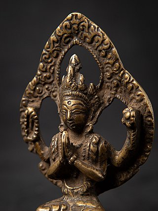 Chenrezig statue close-up in three-quarter view, focusing on the head and halo pattern