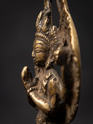 Chenrezig statue close-up side profile showing the prayer hands and flat backplate