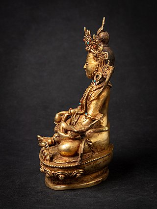 Nepali bronze Kuber statue in left side profile, showing the base and headdress