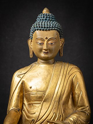 Face and chest detail of the wooden Buddha from Tibet, slightly angled