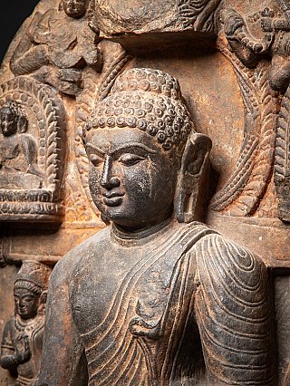 Angled face and shoulder detail of the Buddha with carved stele background
