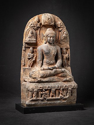 Buddha statue in Pala style from India, seated with halo and attendants, three-quarter right view