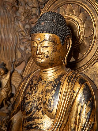 Driekwart detail van het hoofd van Amida Boeddha met vergulding en patina