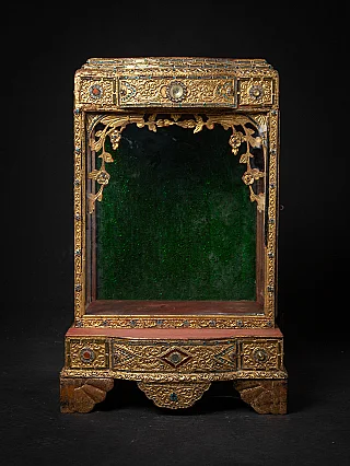 Antique wooden Burmese temple shrine with gilded frame and glass display, front view