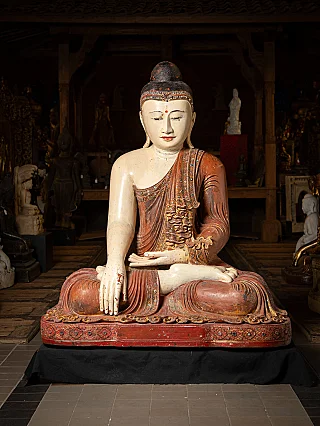Burmese wooden Buddha statue, full front view seated in bhumisparsha mudra on a red base