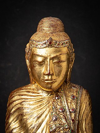Face detail of the Burmese Buddha statue with gilding and decorated headband