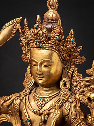 Three-quarter head detail showing crown points and ear ornaments with raised hand in front