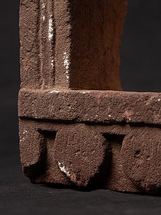 Base detail with rounded motifs and small white wear marks on the stone niche