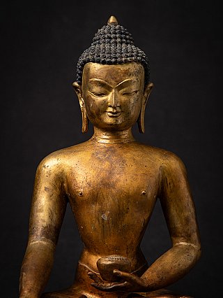 Head and chest detail of a Nepal bronze Buddha statue, with bowl partially visible