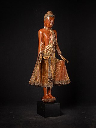 Burmese wooden Buddha statue, three-quarter view highlighting ornate robe border and base