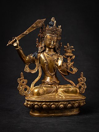 Manjushri Buddha statue in bronze from Nepal, seated angled view with crown, sword and lotus
