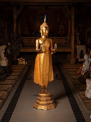 Thai bronze Buddha statue on pedestal, three-quarter view with Abhaya mudra