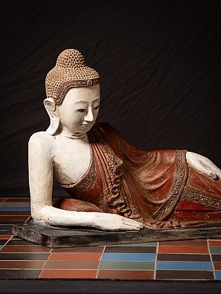 Detail der liegenden Buddha-Statue, Oberkörper mit rotem Gewand und Arm auf Sockel