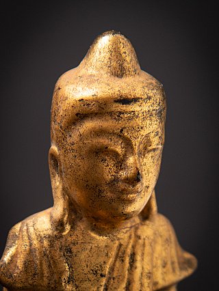Close-up of the head of the Burmese wooden Buddha statue, showing the topknot