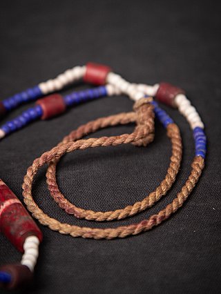 Detail of the cords and beads on the Naga necklace, with red and blue accents