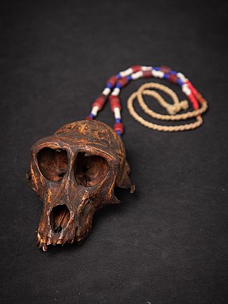 Old Naga necklace from Burma (Myanmar) with wooden monkey skull and bead strand, angled view