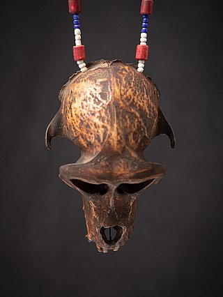 Wooden monkey skull with Naga necklace hanging, front view showing dark patina