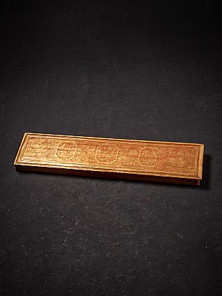 Closed Burmese wooden Kammavaca manuscript book with gilded cover, angled view