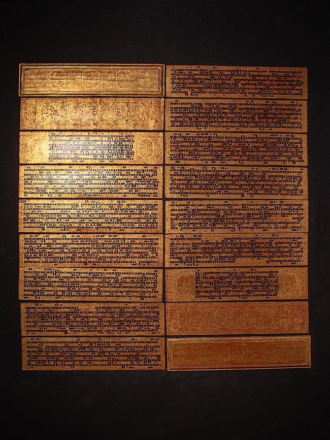 Burmese Kammavaca manuscript plates laid out, showing black script and gilt-style borders