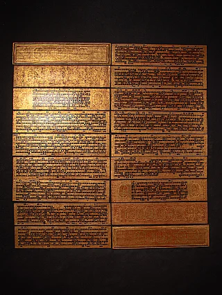 Burmese Kammavaca manuscript plates laid out, showing black script and gilt-style borders