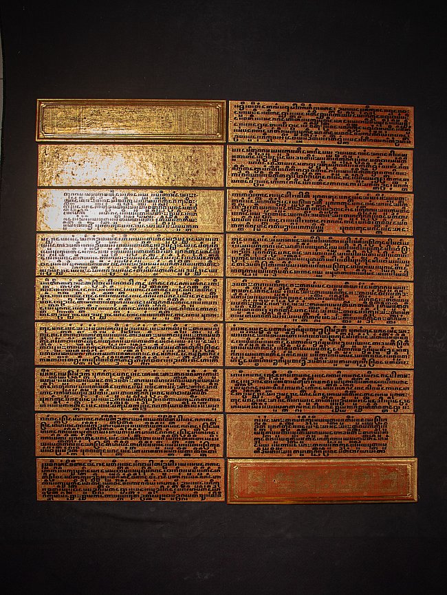 Burmese Kammavaca manuscript laid out as panels with gilded script on a black background