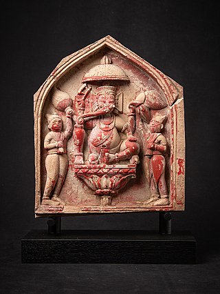 Ganesha-reliëf uit India met rode pigmentresten, frontaal in nisvormig paneel