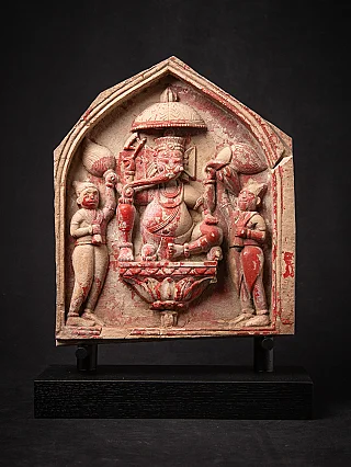 Ganesha-reliëf uit India met rode pigmentresten, frontaal in nisvormig paneel