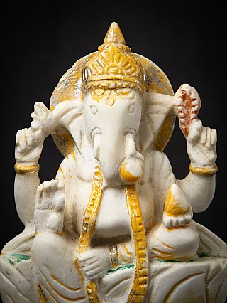 Close-up of the marble Ganesha head with crown and back slab, gold accents