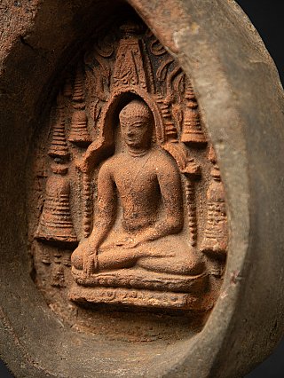 Angled close-up of the seated Buddha relief with the niche rim visible on the Bagan tablet