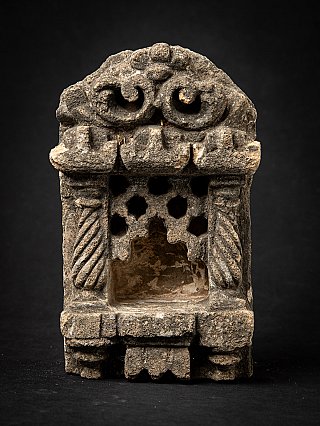 Indian stone temple niche shrine with open recess and carved arch, front view