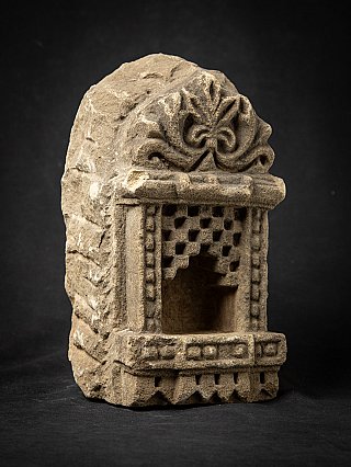 Indian stone temple niche, three-quarter view with floral crest and open recess