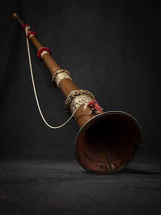 Close-up of the wide bell end of a Nepali dungchen horn, showing patina and metal rim