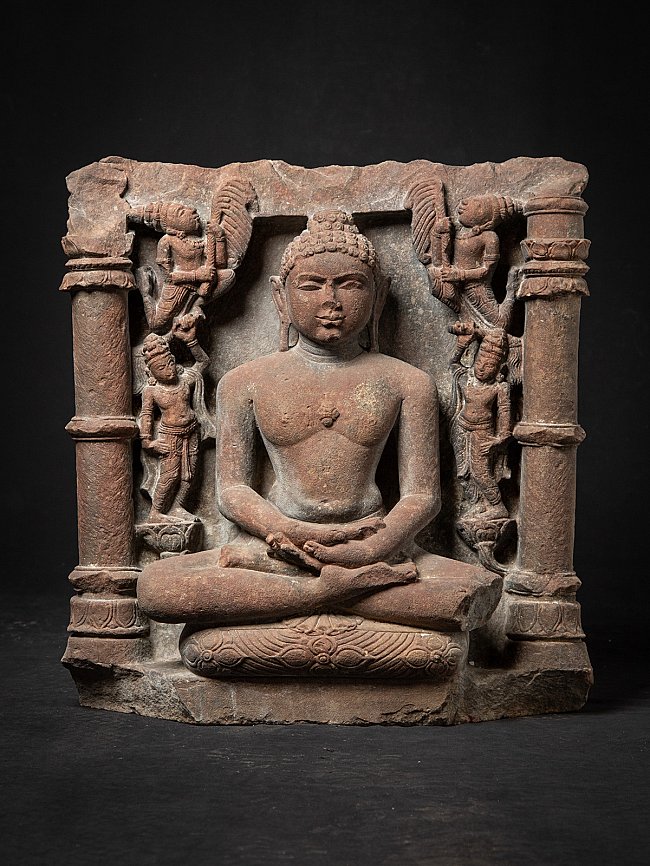 Zittend Jina-beeld uit India in reliëfsteen, frontaal met zuilen en begeleidende figuren