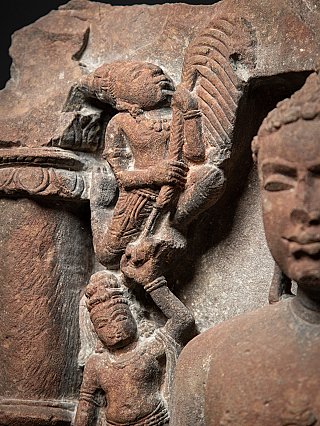 Detail van de bovenste zijfiguur met waaiervormig element, naast het hoofd van de Jina