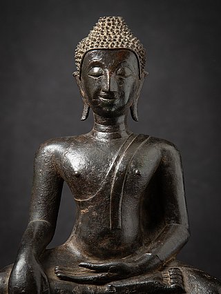 Face and chest close-up of the Thai bronze Buddha statue with elongated earlobes