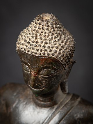 Top head detail of the Thai bronze Buddha statue showing textured hair curls and crown area
