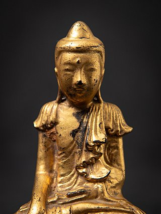 Close-up of the face of the wooden Buddha statue from Myanmar, with small forehead dot