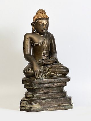 Burmese bronze Buddha statue, seated, three-quarter left view showing the stepped base