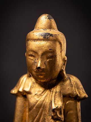 Face and shoulders of the Shan-style Burmese wooden Buddha, showing robe folds