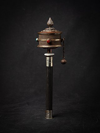Tibetaanse gebedsmolen met houten handvat en metalen cilinder, rechtop met kettinggewicht