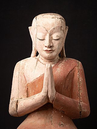 Face and namaskara mudra detail of the Burmese wooden monk statue