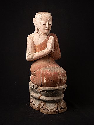 Burmese wooden monk statue in namaskara mudra, three-quarter view on lotus base
