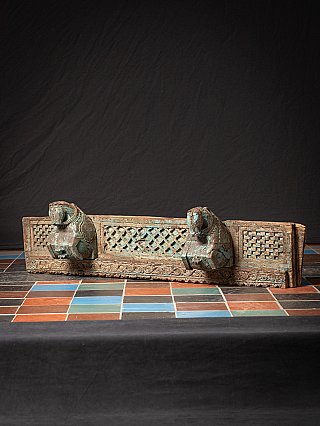 Indian wooden temple panel with two horse heads, full front view from low angle
