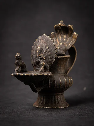 Nepali bronze sukunda oil lamp, 19th century, angled view with dish and small figures