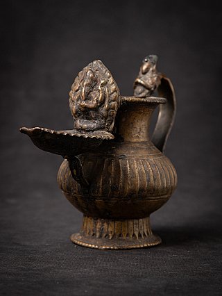 Nepali bronze oil lamp (sukunda), three-quarter view showing spout dish and relief