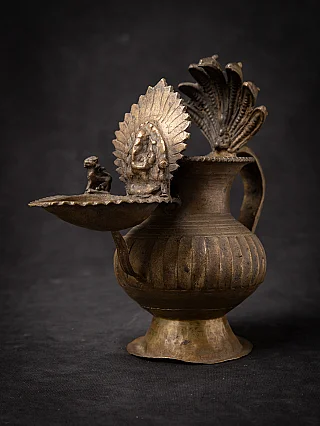 Nepali bronze oil lamp (sukunda) with leaf-shaped backplate and side dish, three-quarter view